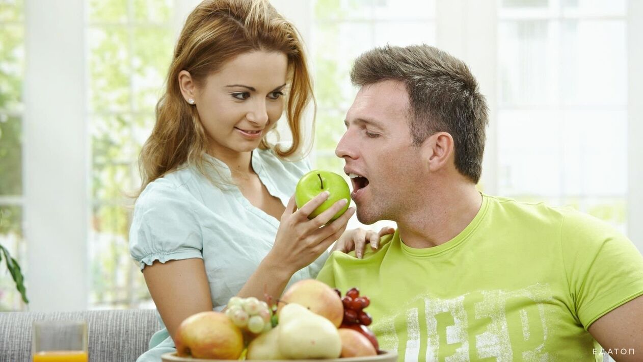 дівчина годує чоловіка корисною їжею